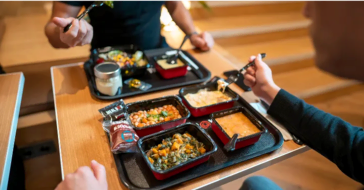 Masasında yemek yiyen iki kişi görseli