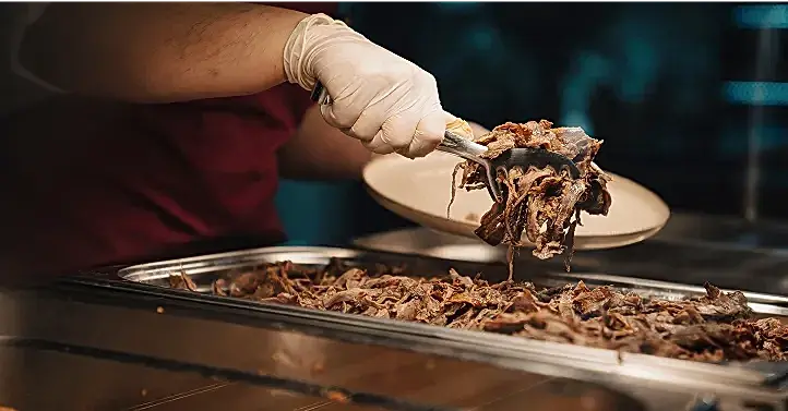 Tabağa servis edilecek yemeği koyan çalışan görseli