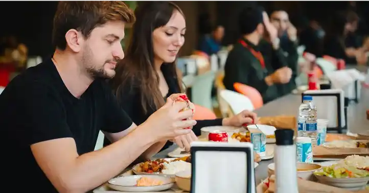 Masada yemek tüketen kişilerin görseli
